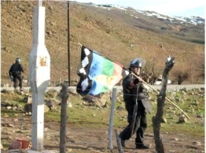 Un gendarme argentino se lleva la bandera de los Mapuches en un desalojo de un campo ocupado, en Neuquén.